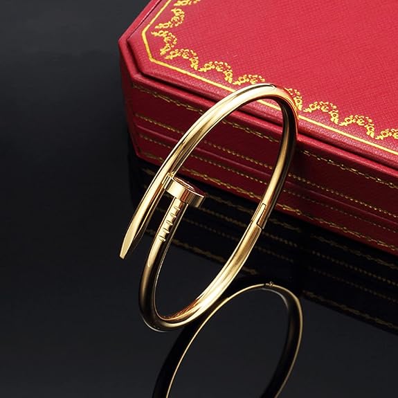 Cartier Nail Gold Bangle Bracelet on a dark surface with a red jewelry box in the background