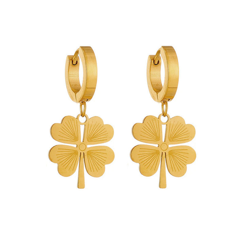 Gold four-leaf clover hoop earrings on a white background
