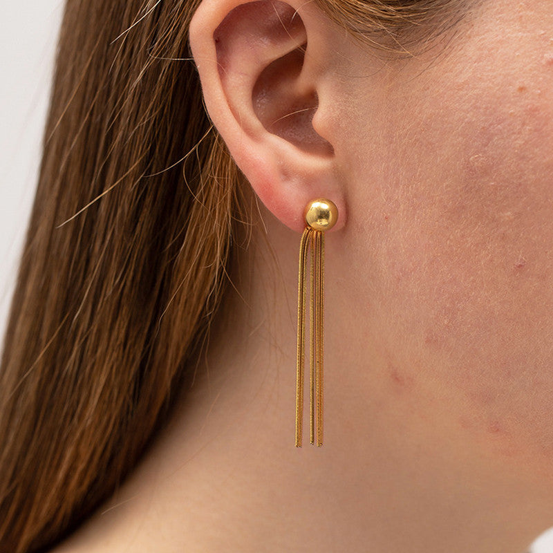 Gold earring with tassels worn by a person