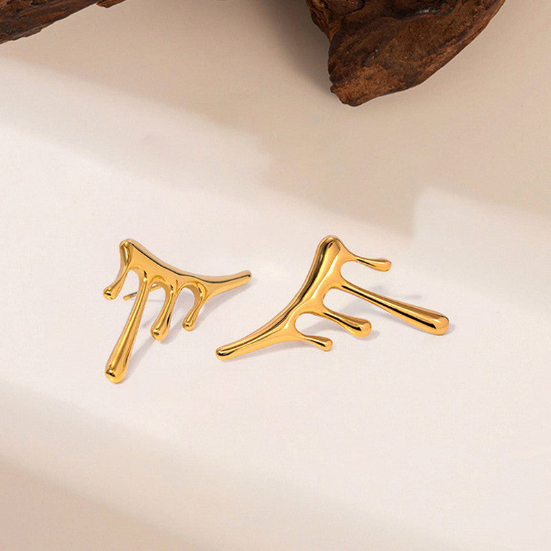 Gold earrings on a beige background
