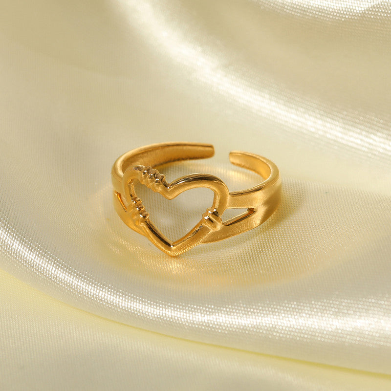 Gold heart-shaped ring on a beige fabric background
