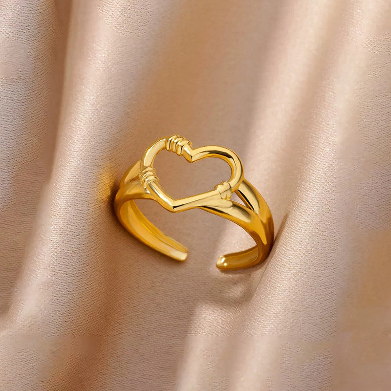 Gold heart-shaped ring on a beige fabric background