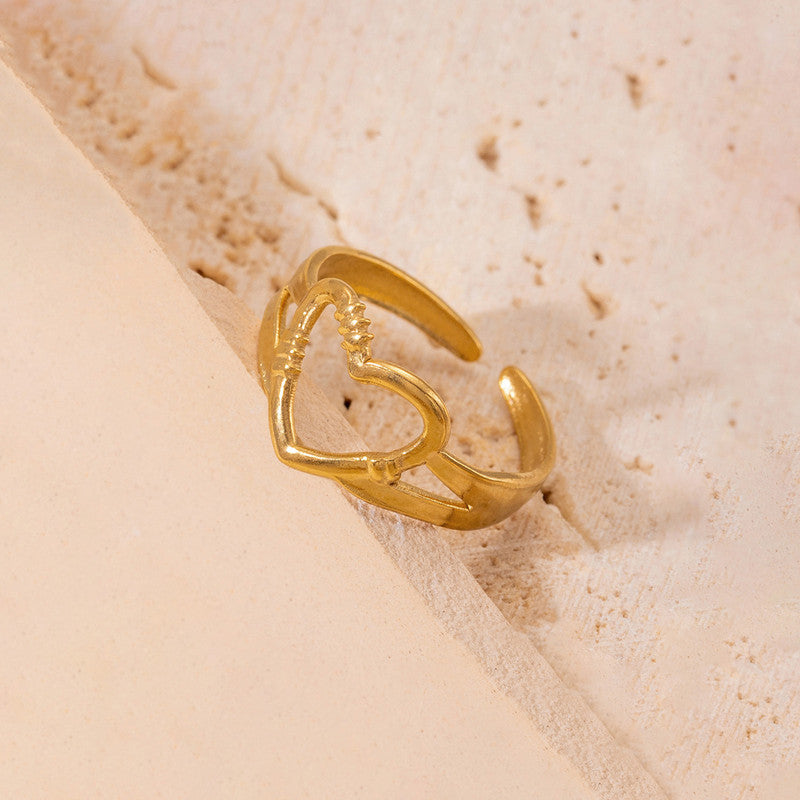 Gold ring with a unique design on a beige sand-like background