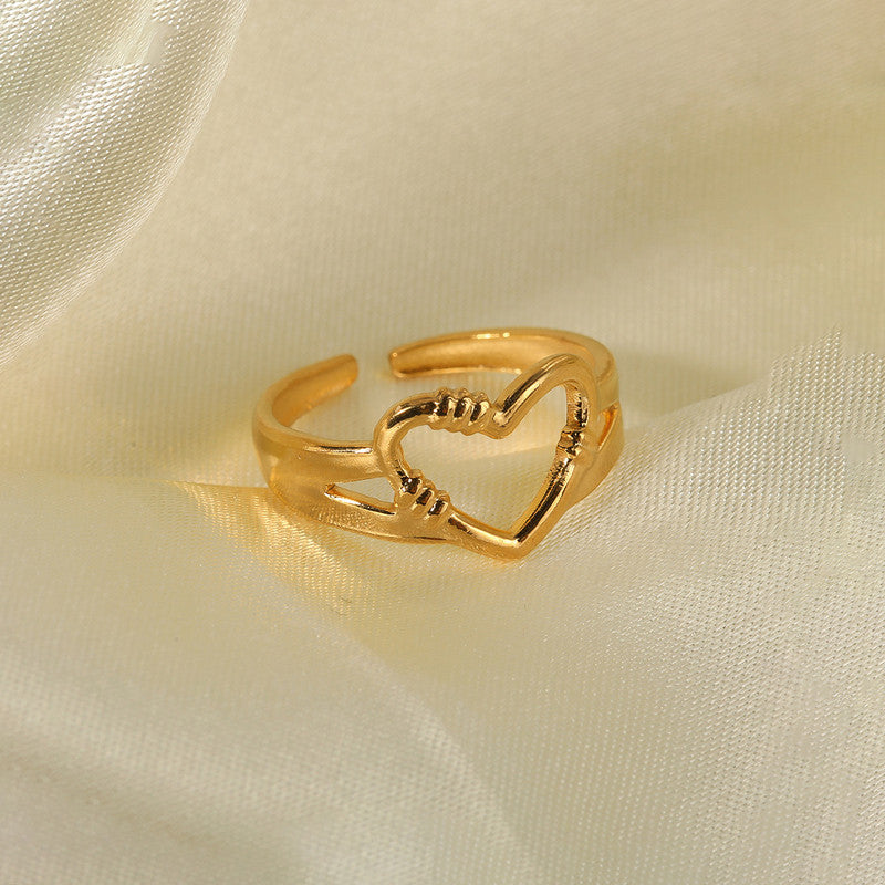 Gold heart-shaped ring on a beige fabric background