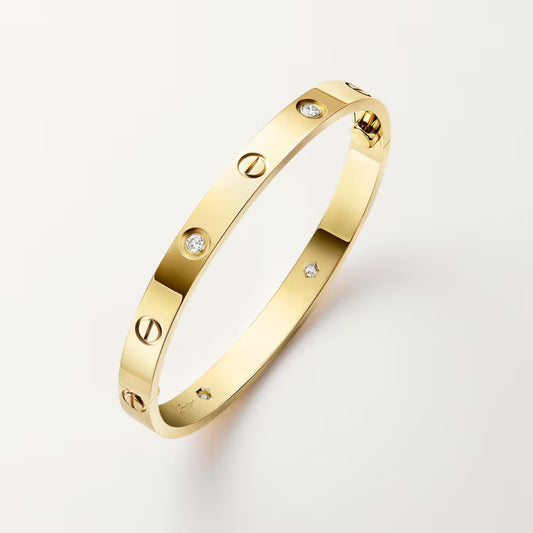 Gold bracelet with diamond accents on a light gray background